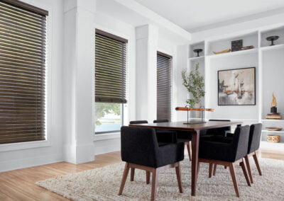 dark window coverings match the dark chairs in otherwise bright room