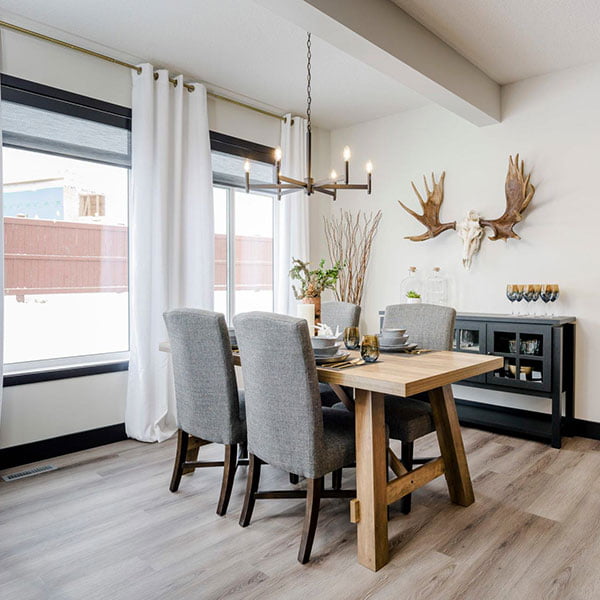 thick wood table in eating area of show home with moose decorations on wall